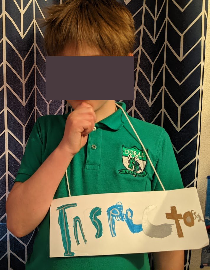 Kid thinking with hand on chin and homemade sign that reads 